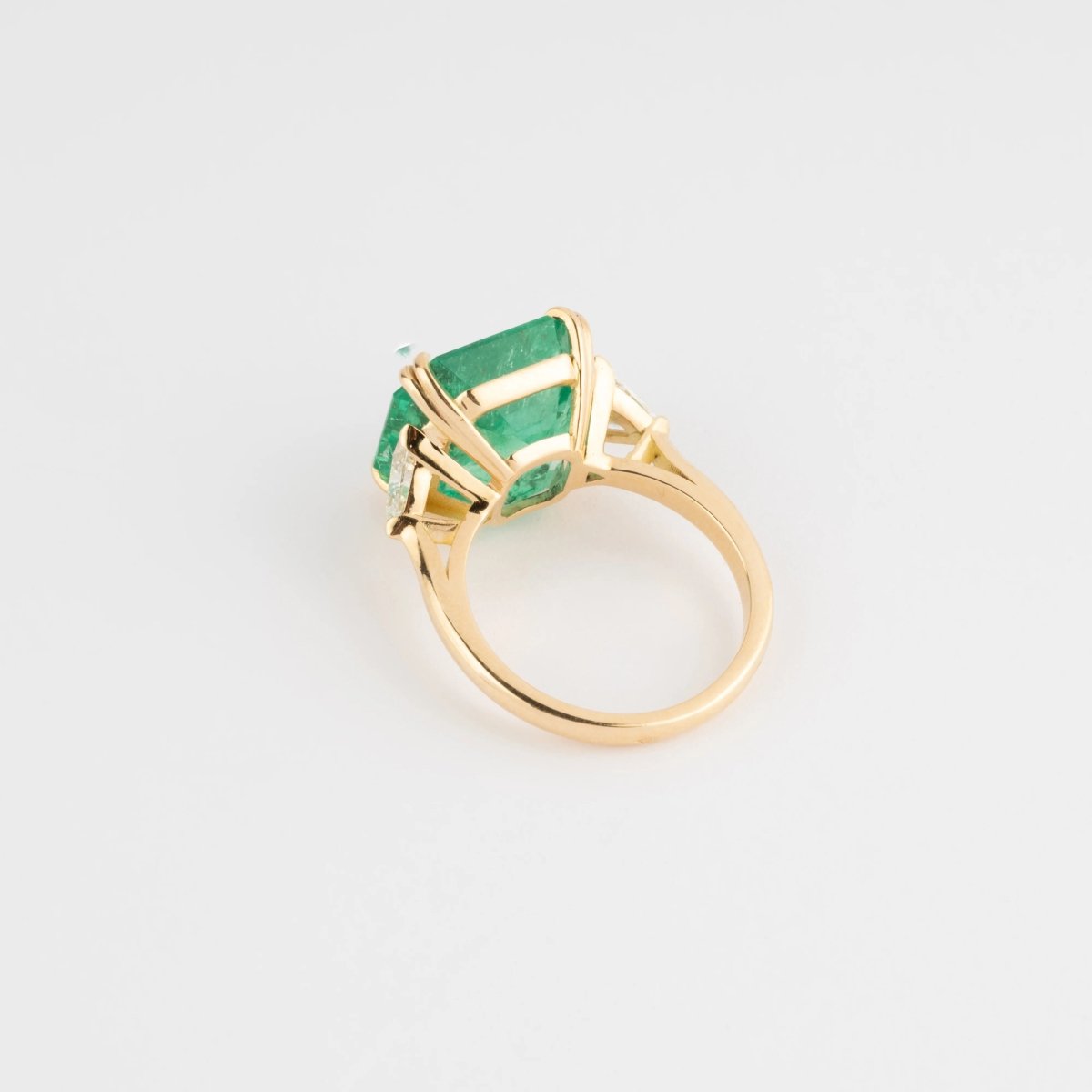 Bague en or jaune ornée d'une émeraude taille émeraude épaulé de diamants triangles - Castafiore