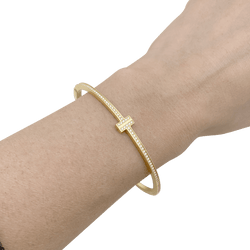 Bracelet Tiffany & Co., "Tiffany T" en or jaune et diamants. - Castafiore