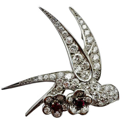 Broche "Oiseau posé sur deux fleurs" en or blanc, platine et rubis - Castafiore