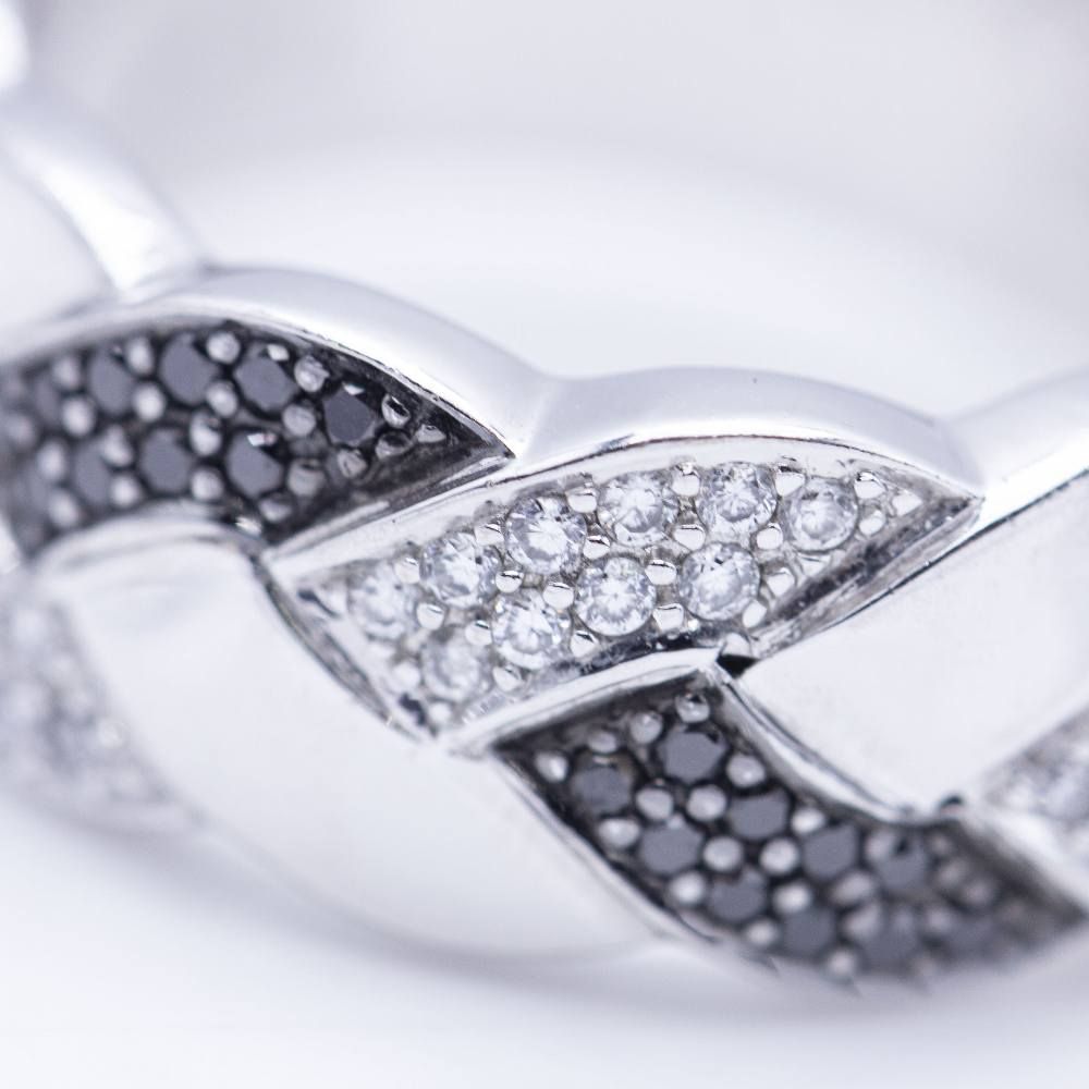 Bague tressée en or blanc avec diamants blancs et noirs.