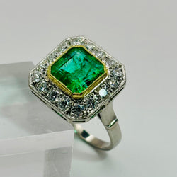 ANILLO DISEÑO VINTAGE EN PLATINO CON ESMERALDA CENTRAL  Y HALO DE DIAMANTES