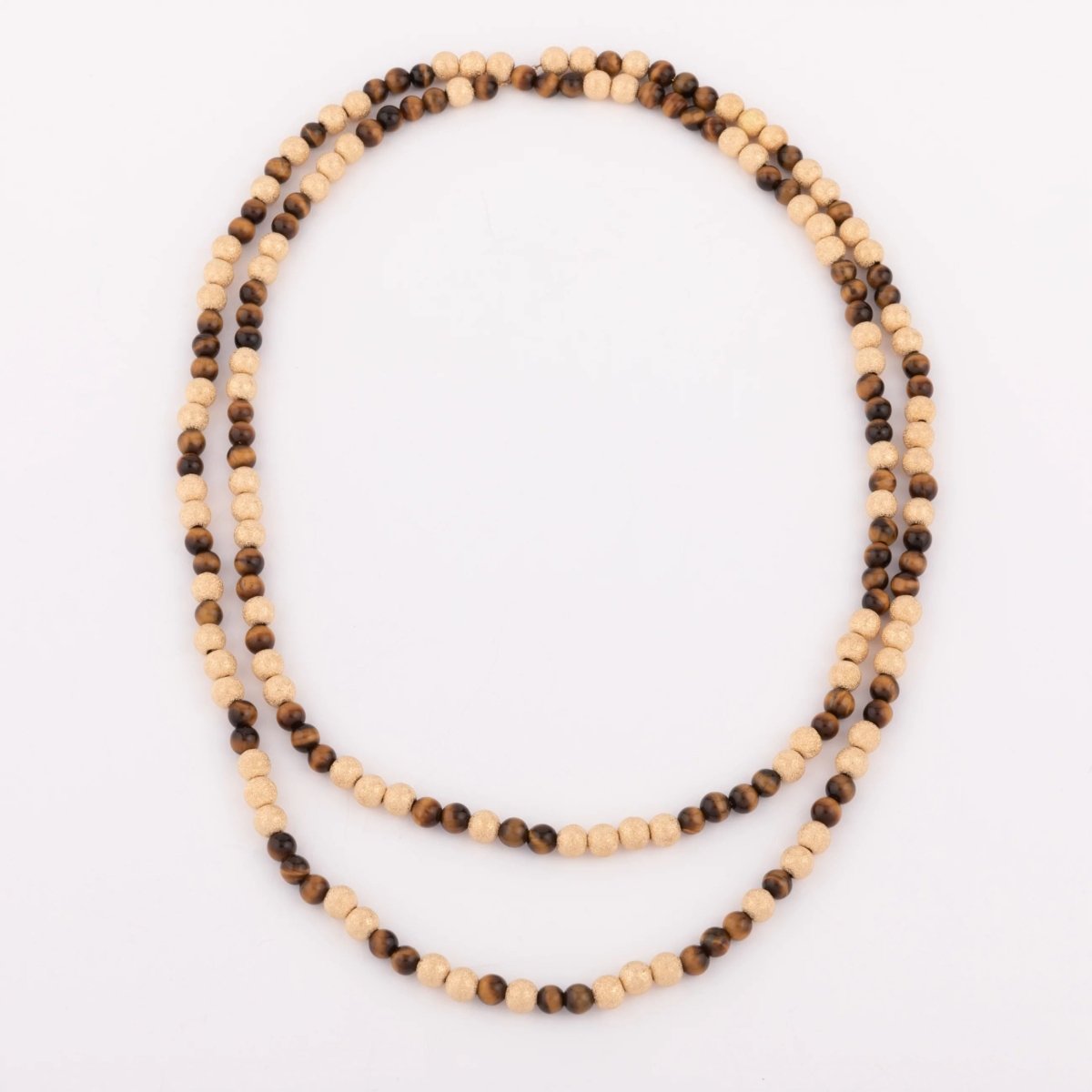 Sautoir en perles d'or ciselés et perle yeux de tigre - Castafiore